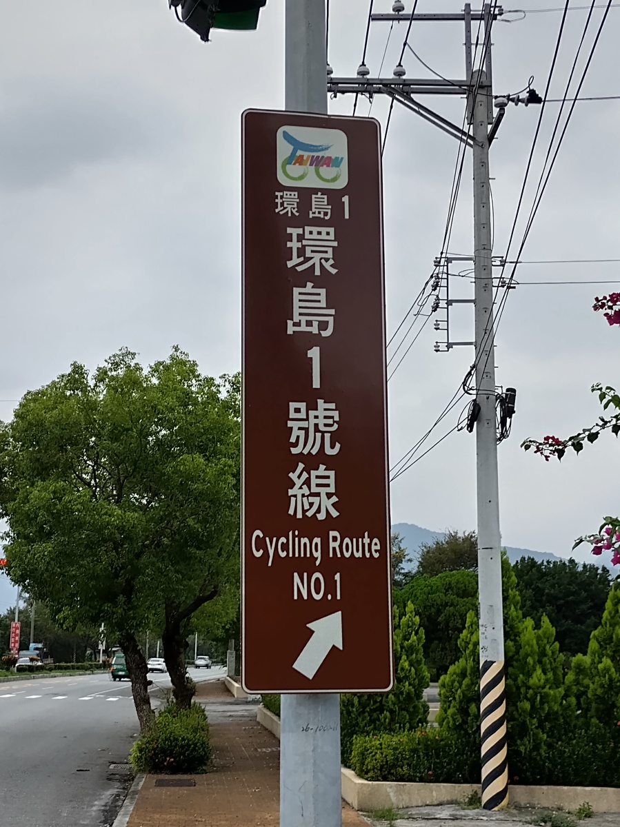 Brown vertical street sign with Taiwan No. 1 Cycling Route written in Chinese and English